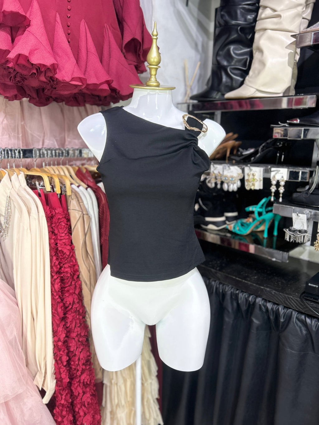 Blusa negra sin mangas con herraje dorado en tirante