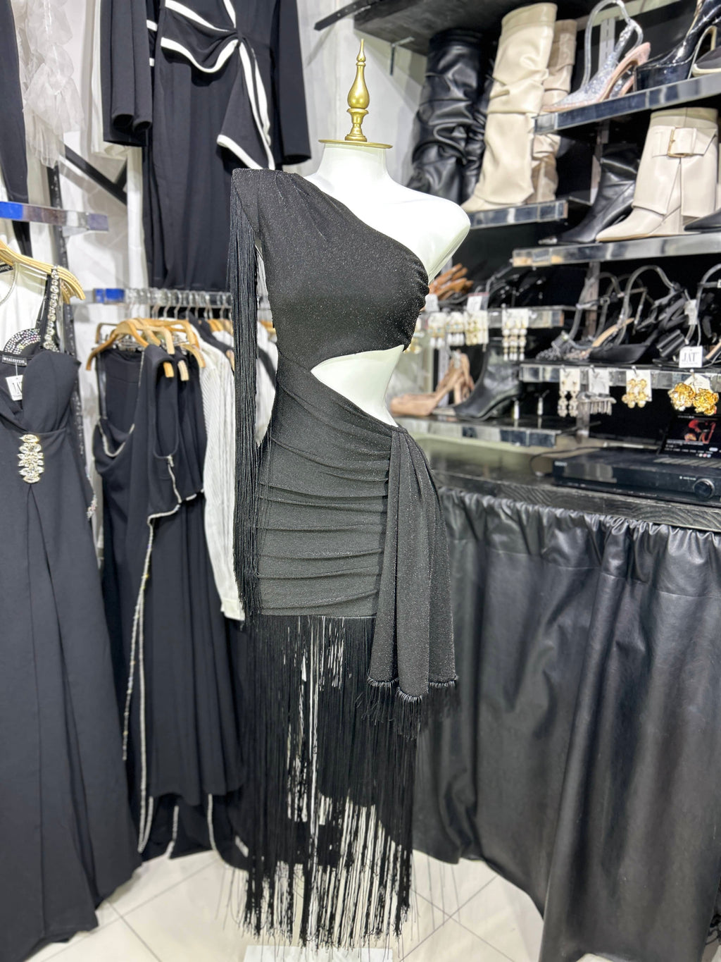 Vestido de un hombro negro con escote en citura y barbas en ruedo y hombro