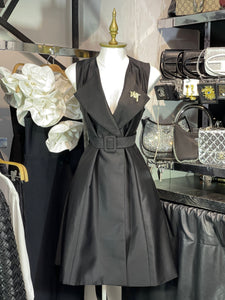 Vestido negro tipo sastre con broche y bolsas funcionales